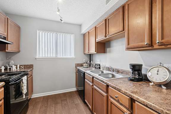 A kitchen with wooden cabinets and a granite countertop.