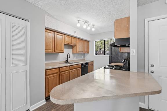 A kitchen with wooden cabinets and a beige island.