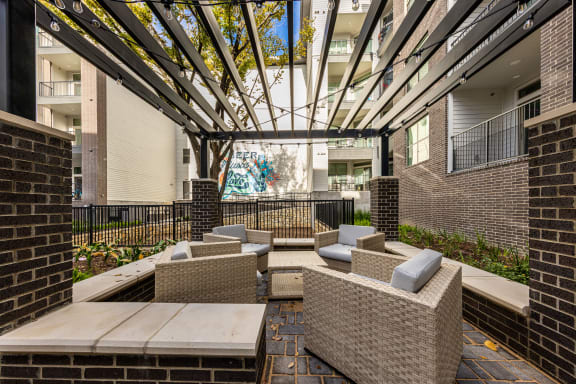 an outdoor patio with chairs and tables and a glass ceiling