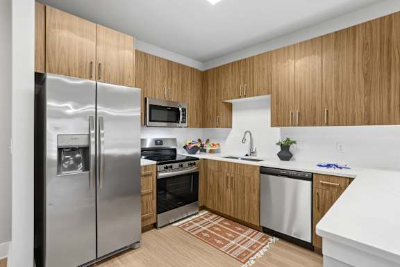 A kitchen with wooden cabinets and a stainless steel refrigerator.