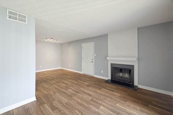 A room with a fireplace and wood flooring.