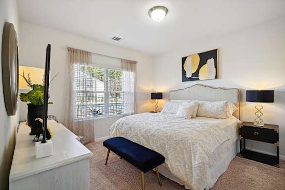 a bedroom with a bed and a dresser and a window