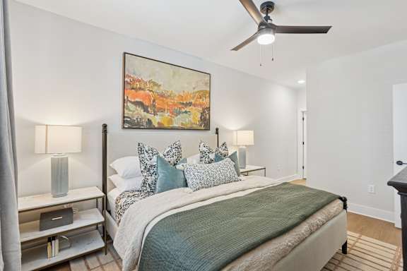 A bedroom with a bed, nightstand, and a painting at Union Eleven Apartments, Georgia