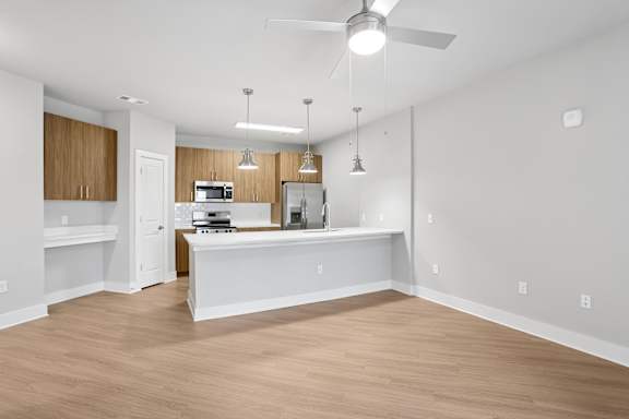 A kitchen with a white countertop and wooden cabinets.