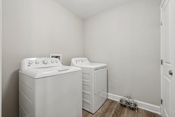 A white washing machine and dryer in a small laundry room.