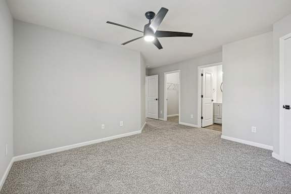 A room with a ceiling fan and carpeted floor.