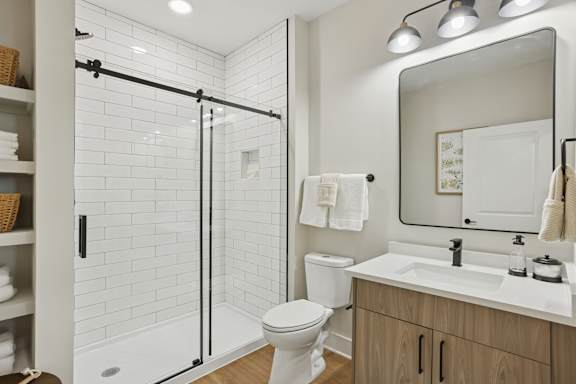 A white toilet sits next to a sink in a bathroom at Union Eleven Apartments, Atlanta, GA