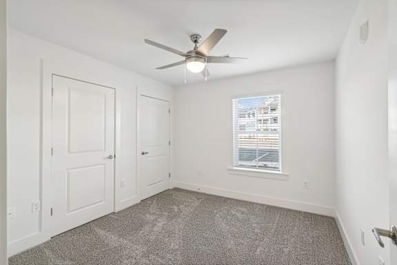 A room with a ceiling fan and a window with blinds at The Parker North Augusta, North Augusta, SC, 29841