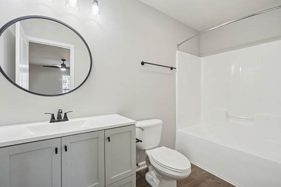 A white bathroom with a toilet, sink, and bathtub.