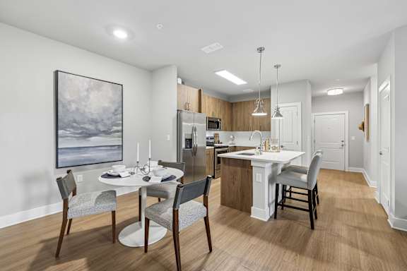 A modern kitchen with a dining table set for four.