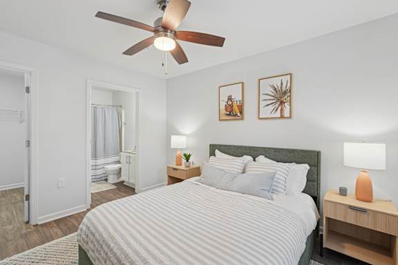 A bedroom with a bed, nightstand, and two wall art pieces.