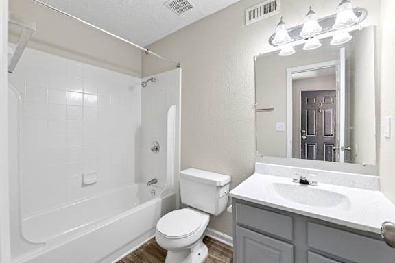 A white bathroom with a toilet, sink, and bathtub.
