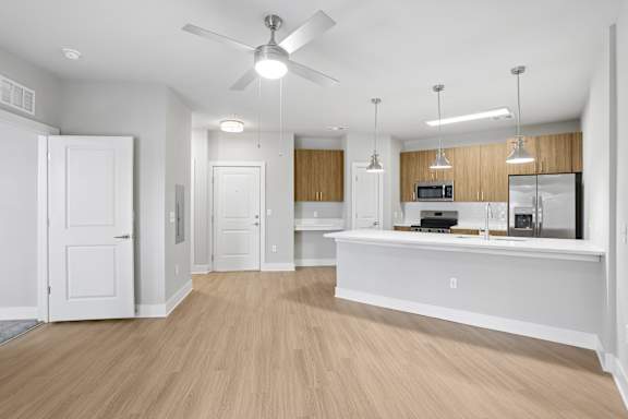 A kitchen with a white counter and a ceiling fan.