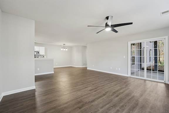 A room with a ceiling fan and wooden flooring.