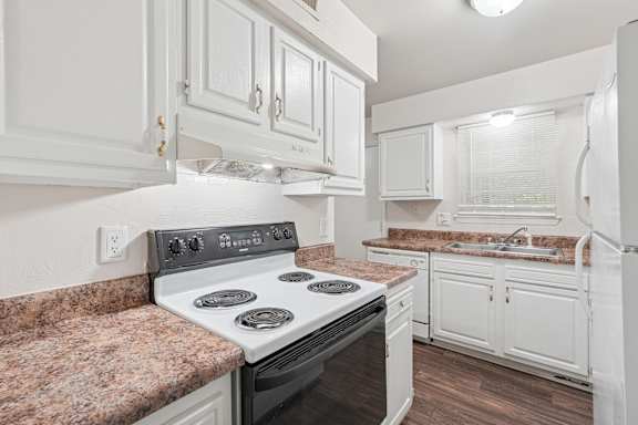 Floor Plan  A kitchen with a stove top oven and white cabinets.