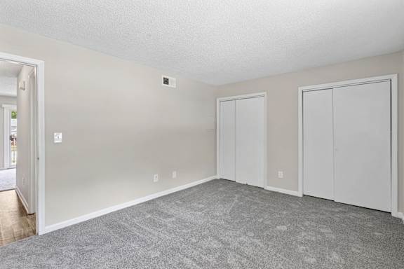 A room with a grey carpet and white walls.