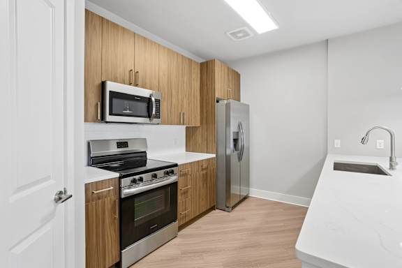 A modern kitchen with wooden cabinets and stainless steel appliances.