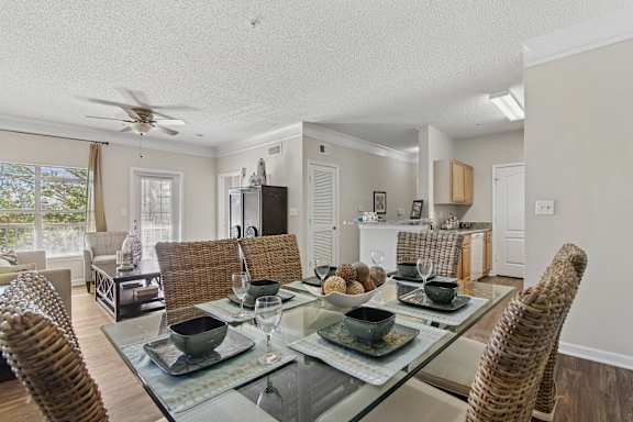 A dining room with a glass table and chairs.