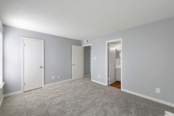 A room with grey carpet and white doors.