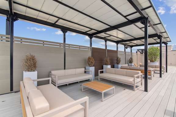 A patio with white furniture and a white roof.