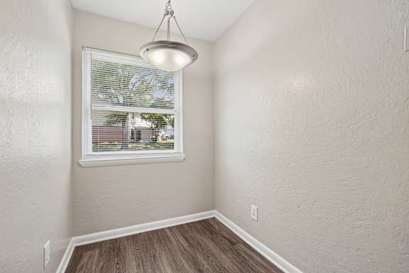 A room with a window and a hanging light fixture.