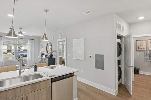 A modern kitchen with a white countertop and stainless steel appliances.