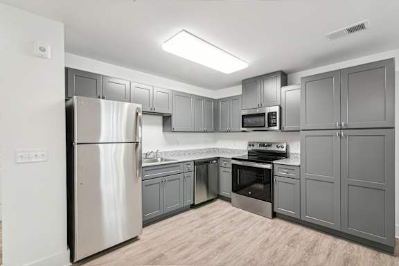 A modern kitchen with a stainless steel refrigerator and wooden flooring at The Parker North Augusta, North Augusta, SC, 29841