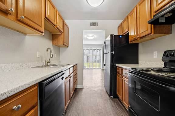 A kitchen with black appliances and wooden cabinets.