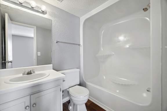 A white bathroom with a toilet, sink, and bathtub.