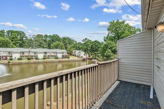 A view from a balcony overlooking a body of water and a row of houses.