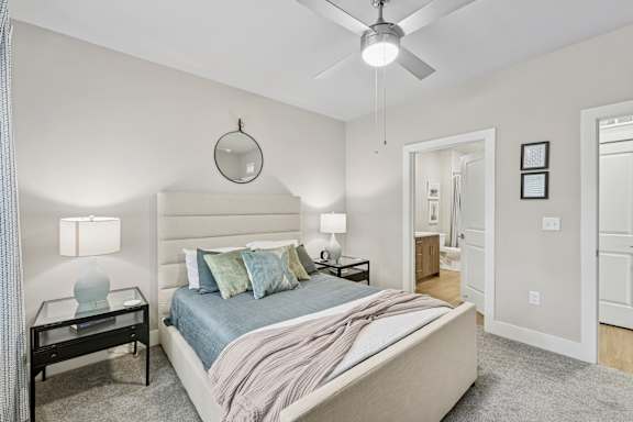 A bedroom with a bed, nightstand, and a ceiling fan.