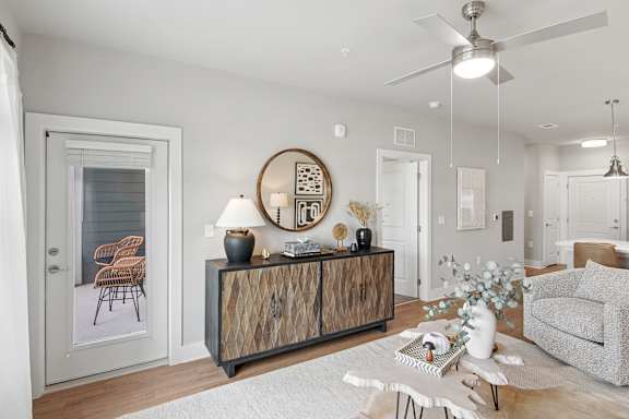 A modern living room with a wooden cabinet and a grey sofa.