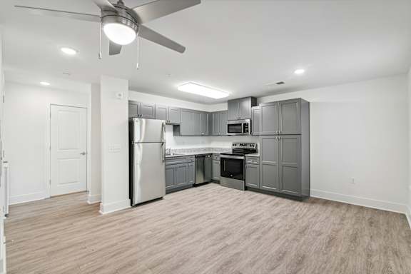 Floor Plan  A spacious kitchen with a refrigerator, oven, and microwave at The Parker North Augusta, North Augusta, SC, 29841