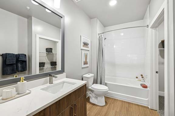 A white bathroom with a toilet, sink, and mirror.