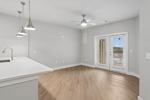 A kitchen with a white countertop and a window with blinds.