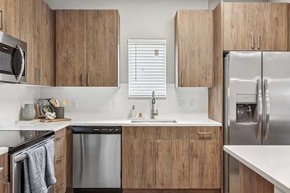 A modern kitchen with wooden cabinets and stainless steel appliances.