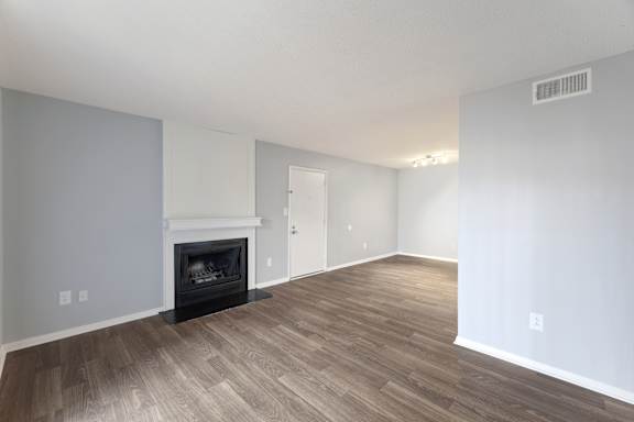 A living room with a fireplace and wood flooring.