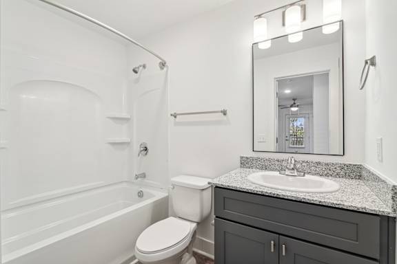 A white bathroom with a toilet, sink, and bathtub at The Parker North Augusta, North Augusta, SC, 29841