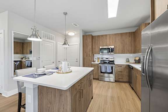 A modern kitchen with wooden cabinets and stainless steel appliances.