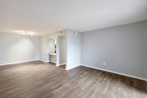 A room with wooden flooring and white walls.