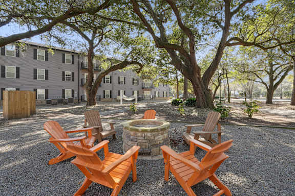 A courtyard with a fire pit and chairs.