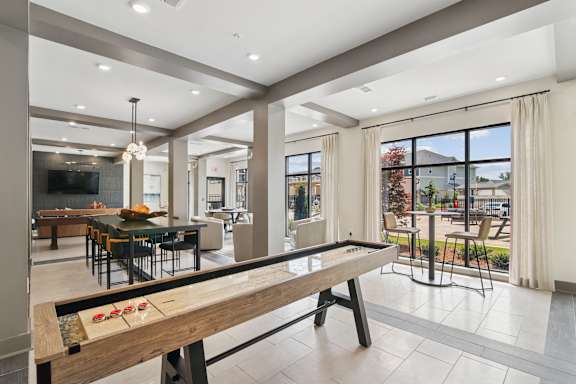 A modern dining room with a long wooden table and chairs.