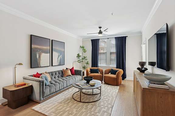 A living room with a grey couch, a coffee table, and a painting on the wall at Union Eleven Apartments, Atlanta, GA