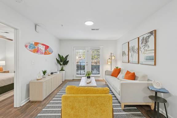 A living room with a yellow chair and a white couch.