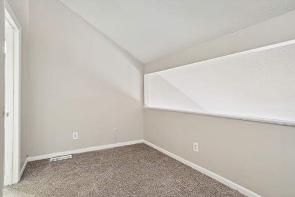 A room with a carpeted floor and white walls.