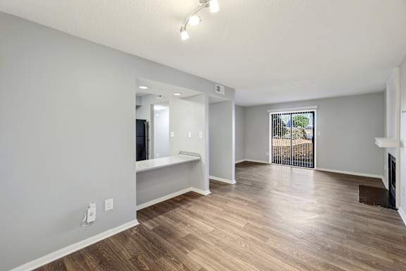 A spacious living room with hardwood floors and a fireplace.
