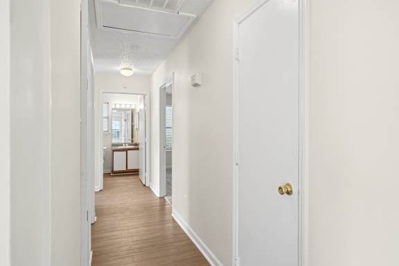 A long white hallway with a door on the right.