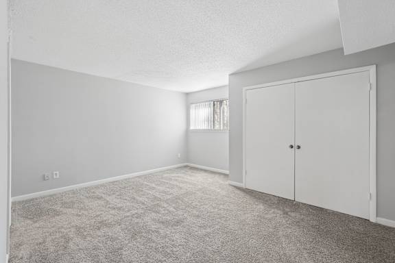 A room with a carpeted floor and a white door.