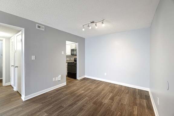 A room with wooden flooring and white walls.