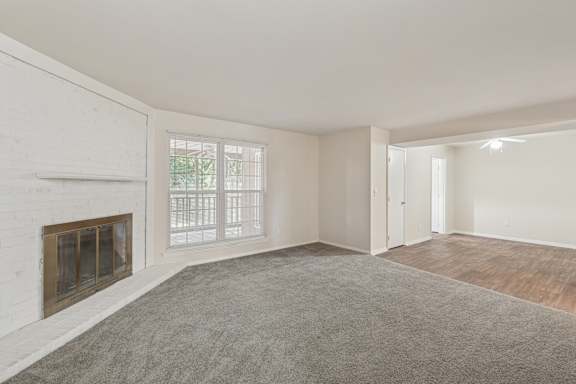 A room with a fireplace and a carpeted floor.